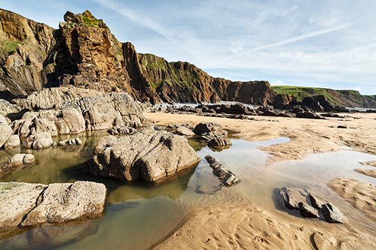 Die Sandsteinküsten bei Bude laden Sie zu einem Strandspaziergang in Cornwall ein.